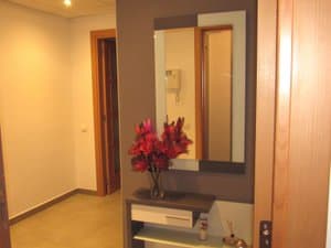 Recibidor con mueble, espejo y flores