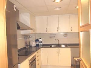 Cocina con muebles blancos, campana y fregadero doble