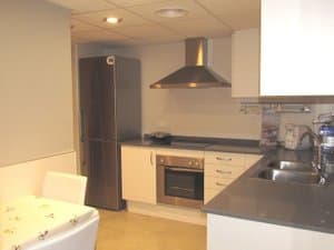 Cocina con frigorífico, horno y mesa