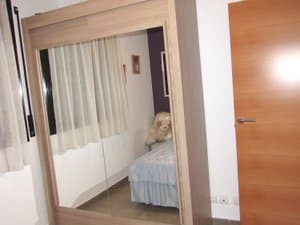Dormitorio con armario de puertas de espejo