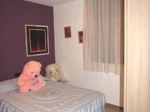 Dormitorio con cama y pared de color