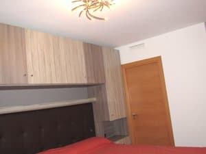 Dormitorio principal con armarios altos sobre la cama
