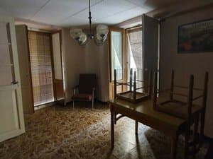 Salón con mesa, sillas y ventanas con persianas