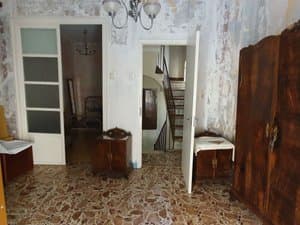 Estancia con puertas de cristal y escalera al fondo