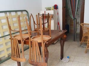 Estancia con mesa y sillas apiladas