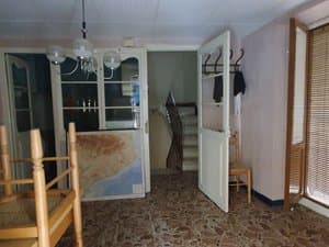 Salón con vitrina y puerta a la escalera