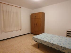 Dormitorio con armario y ventana con cortinas