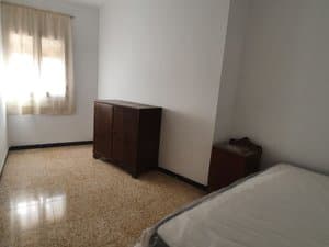 Dormitorio con mueble de madera y cama
