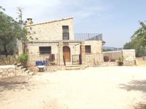 Fachada de piedra con porche y patio de entrada