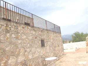 Muro de piedra con barandilla en la terraza superior