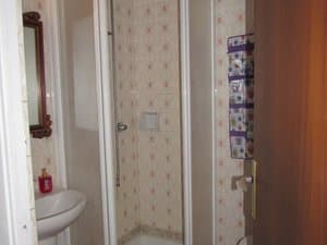 Baño con ducha de mampara y lavabo