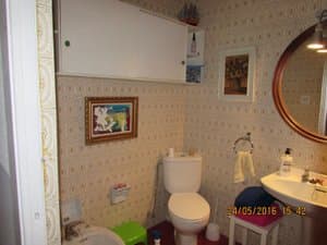 Baño con inodoro, lavabo y espejo redondo