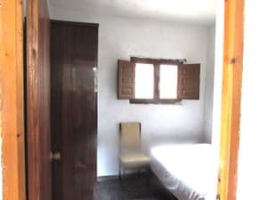 Dormitorio con cama y ventana con porticones