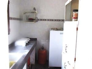 Cocina con fregadero, frigorífico y bombona de gas
