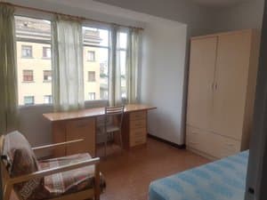 Dormitorio con escritorio, armario y cama