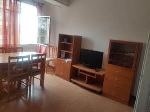 Salón comedor con mesa, mueble de televisión y ventana