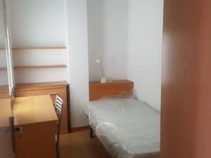Dormitorio con cama individual y escritorio
