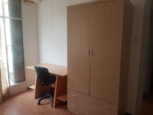 Dormitorio con armario, escritorio y balcón