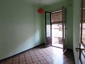 Dormitorio con suelo hidráulico y puerta al balcón