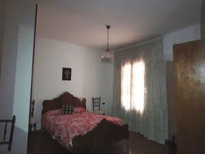 Dormitorio con cama de matrimonio y cortinas