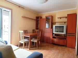 Salón comedor con sofá, mesa y mueble de televisión