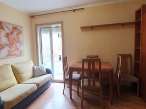 Salón con sofá y puerta al balcón
