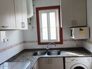 Cocina con fregadero doble, microondas y lavadora