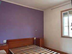 Dormitorio con pared lila y ventana
