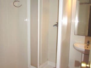Baño con ducha de mampara y lavabo