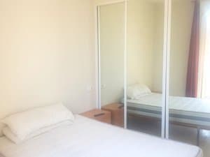Dormitorio con cama y armario de puertas de espejo