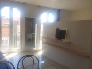 Salón con ventanales en arco y televisor