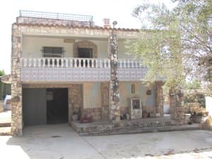 Fachada de piedra con porche y balcón de azulejos