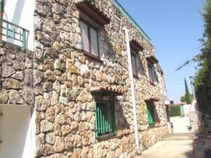 Lateral de piedra con ventanas verdes