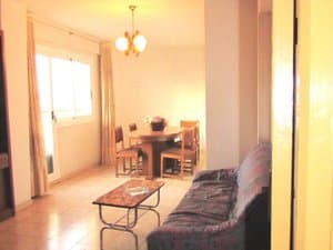 Salón comedor con sofá, mesa baja y ventanal