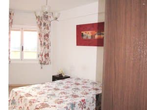 Dormitorio doble con ventana y cortinas de flores