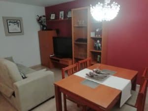 Salón con mesa, sofá y mueble de televisión