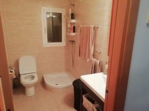 Baño con plato de ducha, inodoro y ventana