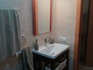 Baño con lavabo sobre mueble y espejo