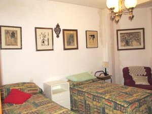 Dormitorio con dos camas y cuadros