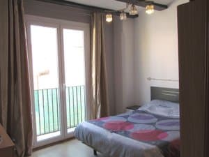 Dormitorio con cama de matrimonio y salida al balcón