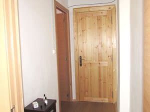 Recibidor con puerta de entrada de madera