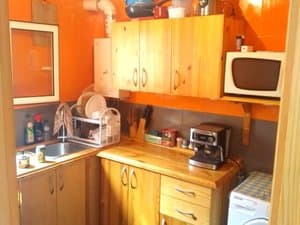 Cocina con muebles de madera, microondas y fregadero