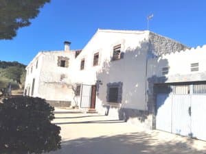 Lateral de la masía con puerta de garaje