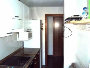 Cocina con placa de inducción y muebles blancos
