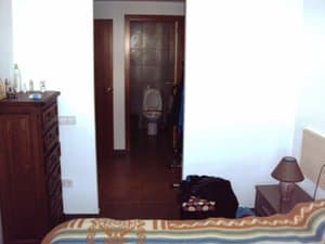Dormitorio con cómoda y puerta al baño