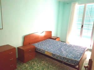 Dormitorio con cama de matrimonio y ventanal