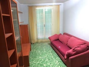 Salón con sofá rojo y cortinas