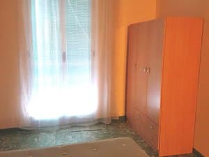 Dormitorio con armario y ventana