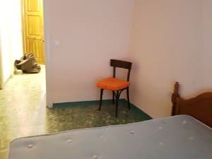 Dormitorio con cama y silla