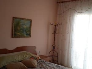 Dormitorio con cama, cuadro y ventanal